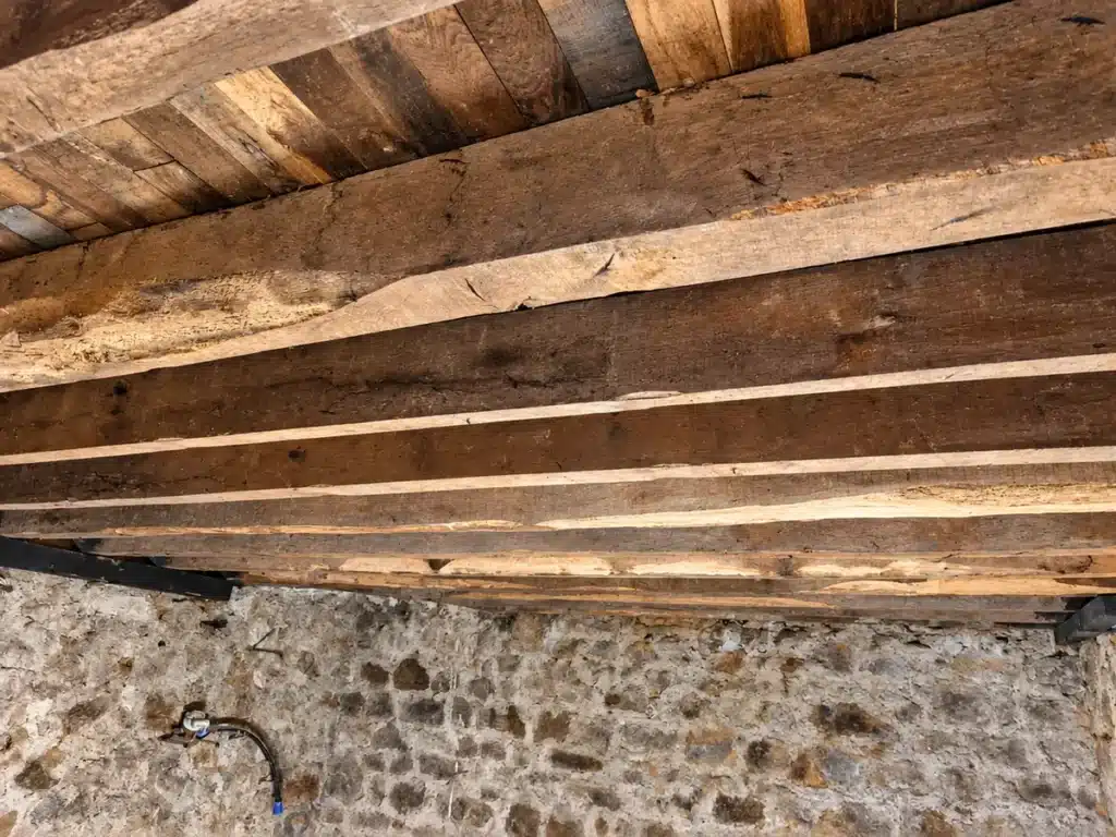 Plancher ancien avec solives en bois apparentes avant travaux d'isolation thermique à Fougères (35).