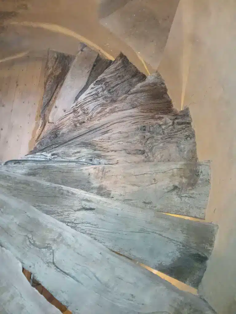Escalier ancien en bois aux marches décapées, dans le cadre de travaux de sablage du bois à Lannion.