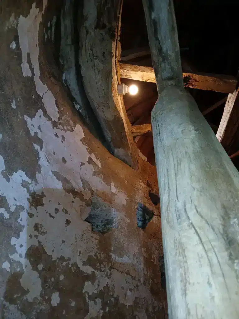 Poutres anciennes apparentes et mur en pierre dans un bâtiment faisant l'objet de travaux de sablage à Lannion.