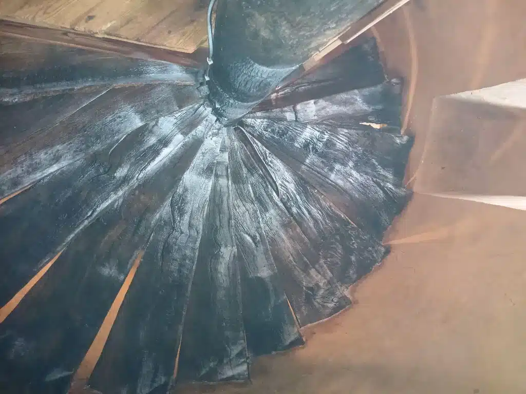 Marches d'un escalier en bois ancien présentant une surface foncée sur un chantier de sablage à Saint-Brieuc.