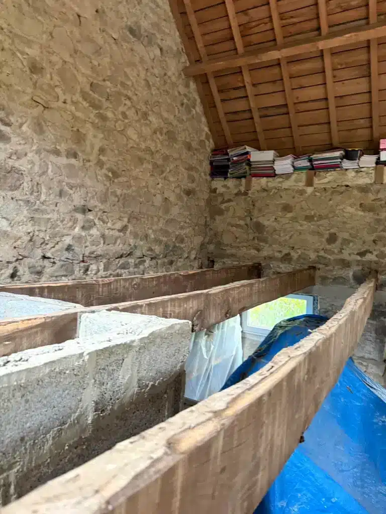Gros plan sur des poutres anciennes et des éléments de toiture en bois lors d'un chantier à Lannion.