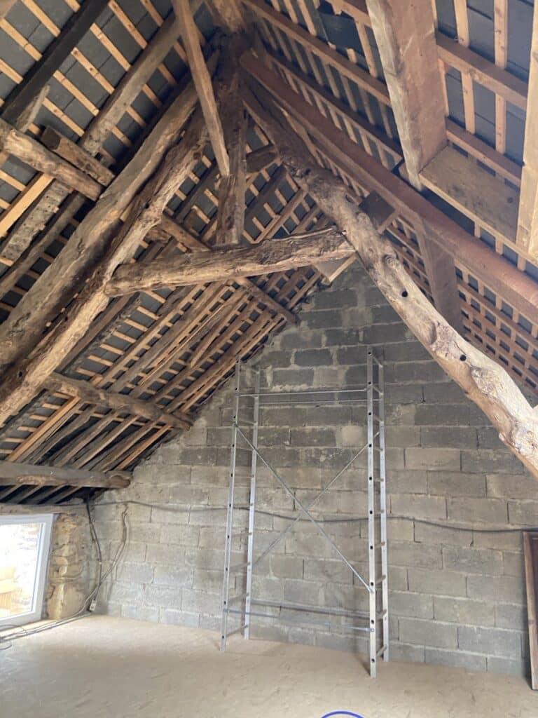 Charpente traditionnelle en chêne dans des combles en rénovation, vérifiée avant un traitement bois près de Rennes